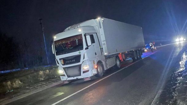 Смертельна ДТП на Берестейському: 21-річний водій Maserati загинув Вантажівка MAN з увімкненими фарами зупинена на узбіччі темної дороги вночі, на задньому плані — мигалки поліцейського авто