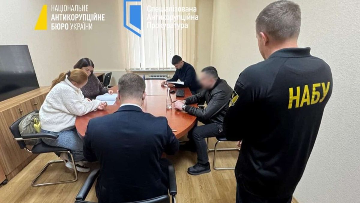 Подружжя депутатів від «Слуги народу» підозрюють у приховуванні 8 мільйонів гривень Працівники НАБУ та САП проводять слідчі дії в офісі — кілька людей сидять за столом