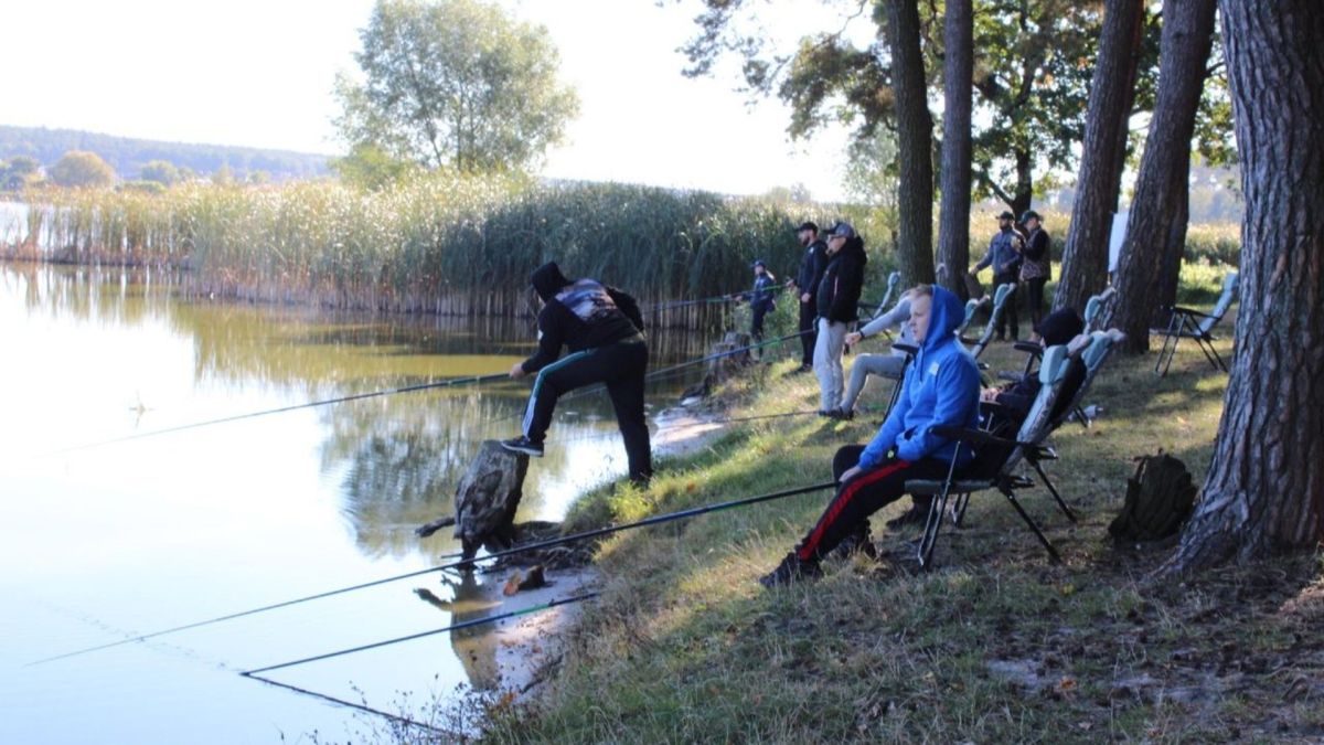 «Київ мілітарі хаб» влаштував риболовлю для ветеранів на реабілітації Група людей на березі ловить рибу