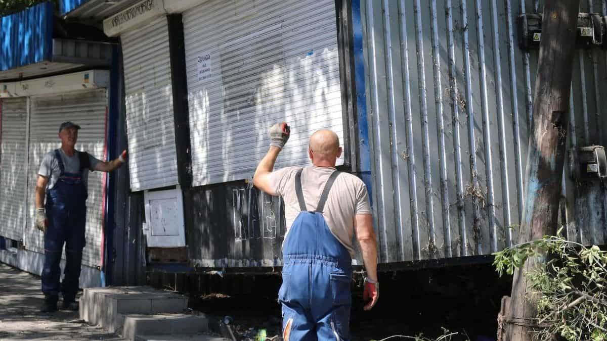 У Києві на проспекті Європейського Союзу знесли 11 кіосків, що простояли майже 20 років Зруйновані каски та пошкоджені металеві конструкції міського ринку в Києві після обстрілу російськими військами. Це кадри міського відновлення та показ підтримки місцевих мешканців у складних умовах.