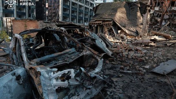 Атака на Київ 2 липня: затримуються 25 тролейбусів і 7 трамваїв Повністю вигорілий каркас автомобіля на тлі зруйнованої будівлі після ракетного удару по Києву