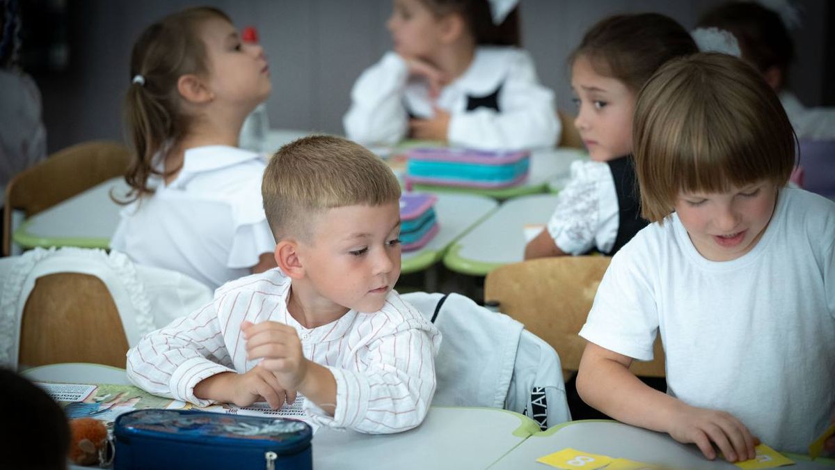 У КМДА пояснили, як працюватимуть школи та дитсадки після нічної атаки Діти в білих сорочках сидять за партами в класі та займаються творчістю