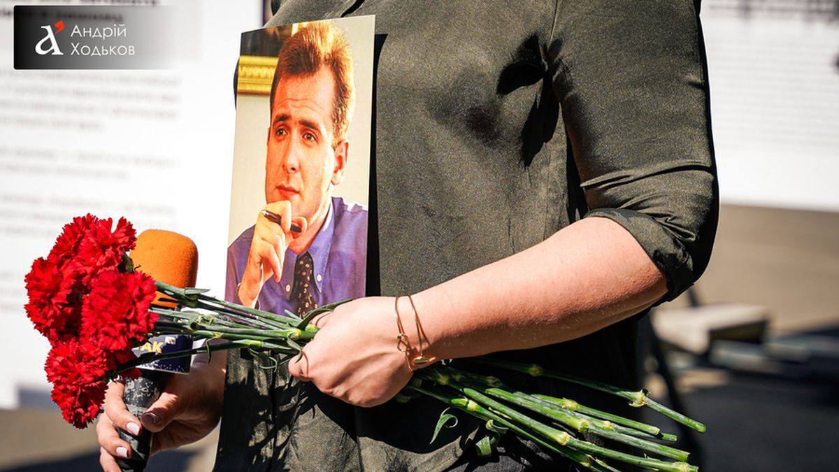 У Києві вшанували пам’ять Георгія Гонгадзе у 25-і роковини його зникнення Крупний план рук із букетом червоних гвоздик та портретом Георгія Гонгадзе