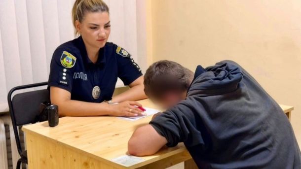 У Білій Церкві 21-річний чоловік катався на даху авто заради «жарту» — поліція склала протокол Поліцейська у формі складає протокол у відділку, поруч сидить чоловік із прихованим обличчям