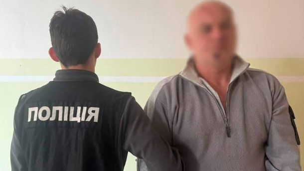 Начальнику київської поліції, який втік з грошима, вручили підозру Поліцейський тримає під руки чоловіка