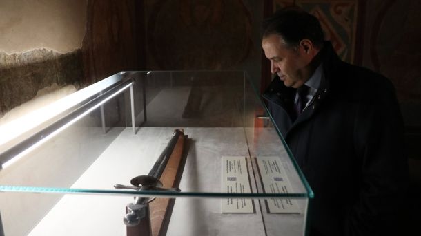 Три новопризначені посли розпочали місію в Києві з візиту до Софійського собору Новопризначений посол оглядає експонат у скляній вітрині на тлі стародавніх фресок Софійського собору в Києві