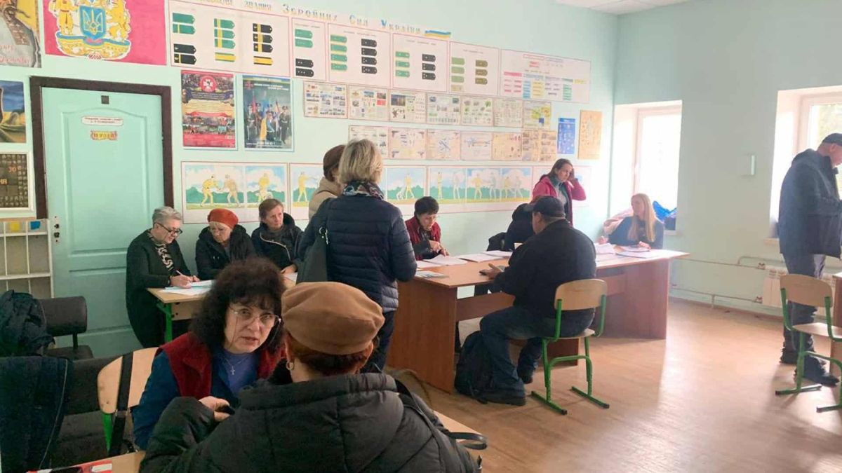 Подільський район Києва: штаб допомоги продовжує роботу після російських атак У приміщенні працюють кілька людей за столами