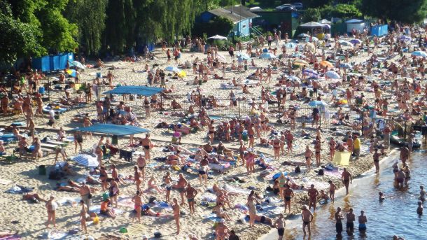 Підтримка тих хто підтримав нас: пільги на комунальні послуги для родин ветеранів Піщаний пляж у київському Гідропарку на березі Дніпра з відпочиваючими людьми влітку