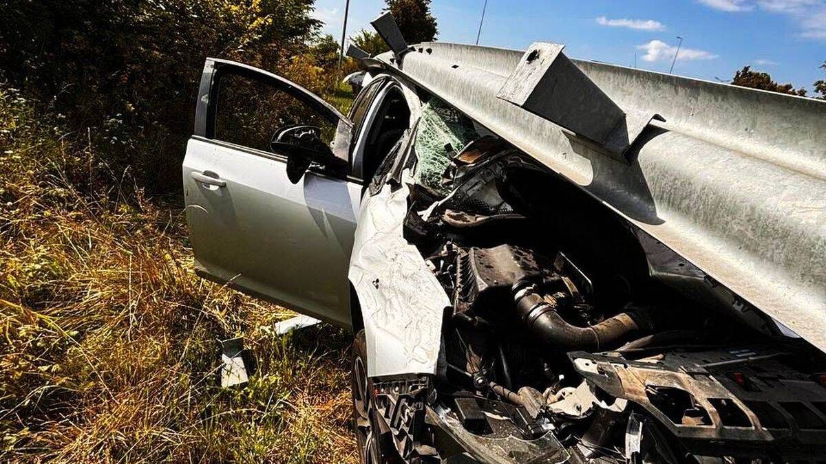 Висока смертність на дорогах Київщини: експерти критикують мізерні штрафи Розбита автівка в полі після аварії, пошкоджений кузов та двигун, викликана аварійна ситуація на трасі. Місце ДТП з розбитим автомобілем і гілками поруч, на фоні дерева та ясне небо.