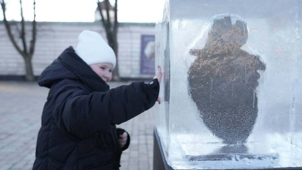 Благодійна акція «Один за одного: Різдво» збирає кошти для воїнів 141 ОМБр Жінка прикладає руку до крижаної брили, з якої лунає різдвяна пісня «Бога тінь»