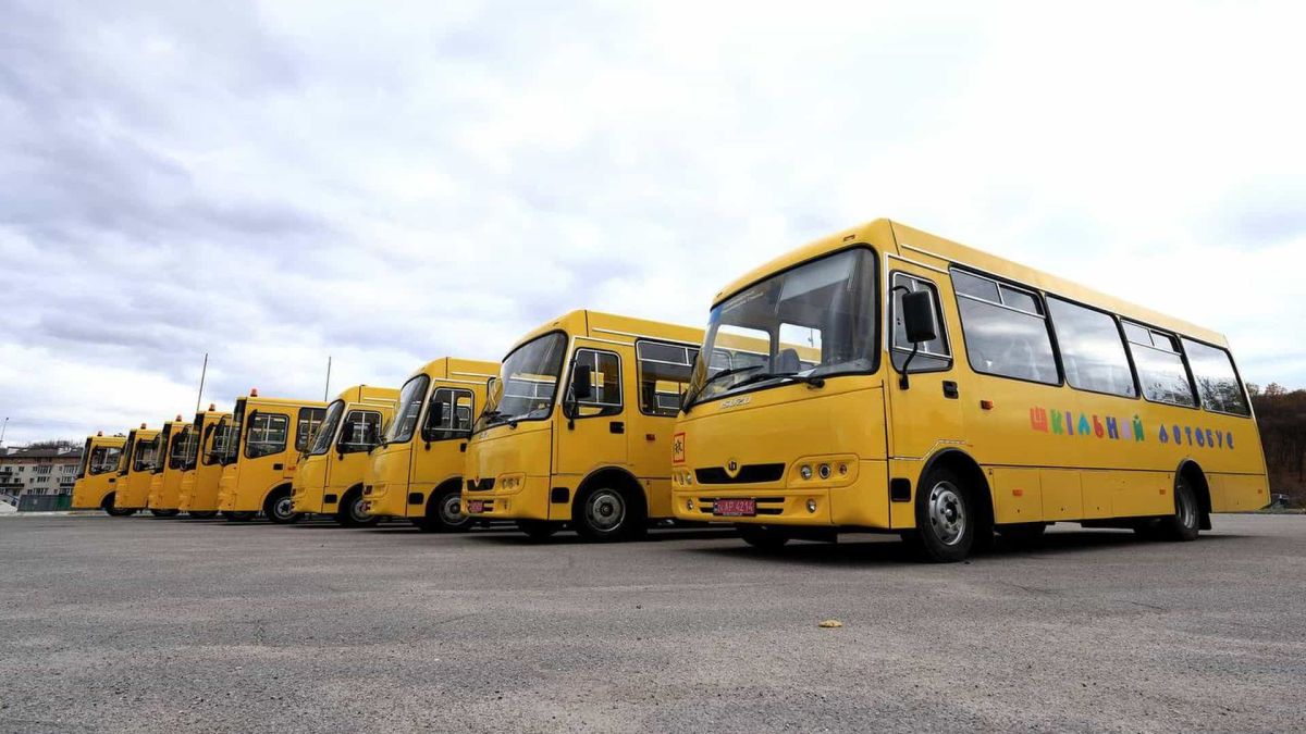9 громад Київщини отримали нові шкільні автобуси Шкільні автобуси - жовті типу "Богдана" стоять в ряд на стоянці, їх 9 штук.