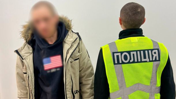 Суд продовжив арешт водію Mercedes, який побив велосипедиста на Подолі Чоловік в бежевій куртці стоїть біля поліцейського