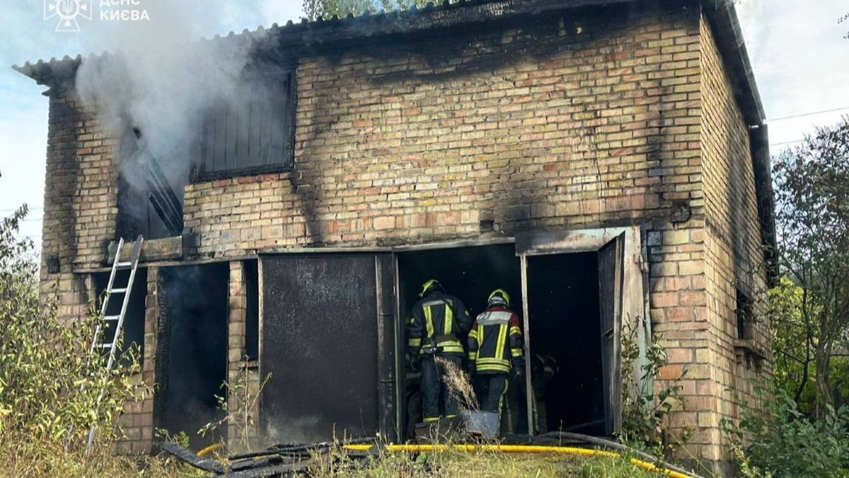 У Дарницькому районі під час пожежі загинула людина — ДСНС Двоє рятувальників гасять пожежу у двоповерховому цегляному гаражі в Києві, з якого йде густий дим