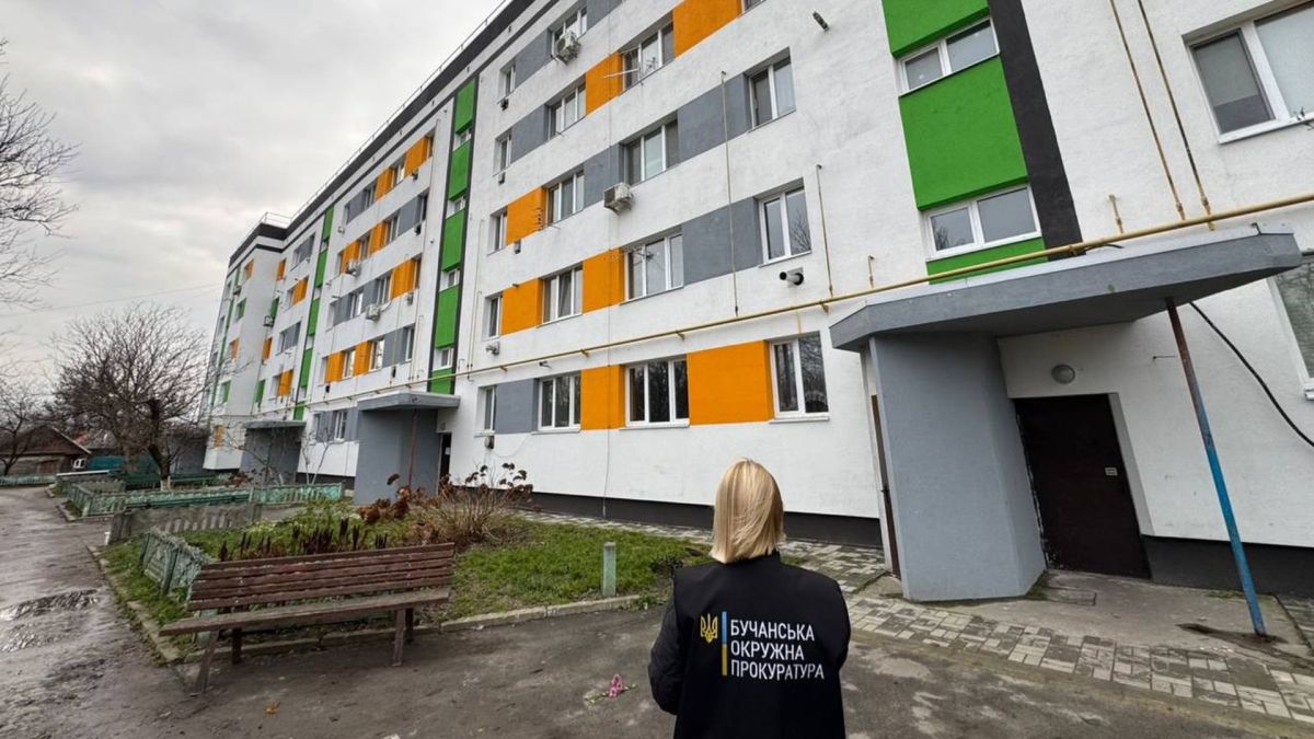 Після атаки РФ багатоповерхівку на Макарівщині «відновили» лише на папері Жінка в чорній куртці із надписом Прокуратура області стоїть біля багатоповерхового житлового будинку