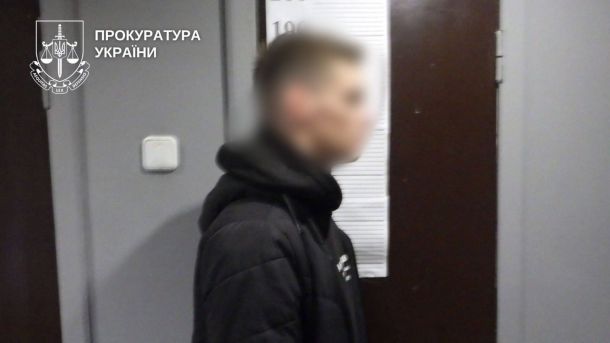 Бенефіціару банку повідомили про підозру: схема на 100 млн грн Молодий чоловік у чорній куртці стоїть біля дверей у приміщенні прокуратури — підозрюваний у збуті наркотиків у Києві