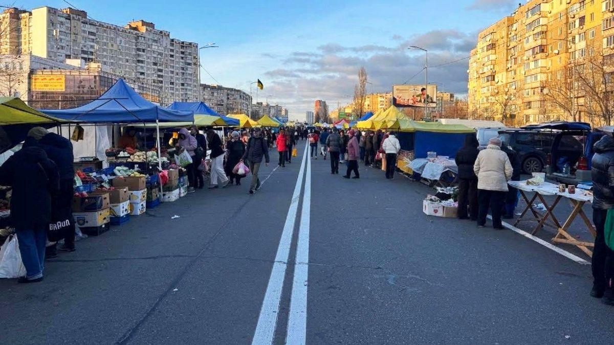 Вихідними в Києві обмежать рух на Набережному шосе та змінять маршрути п'яти автобусів Продуктовий ярмарок на перекритій вулиці Києва: ряди синіх та жовтих наметів з продавцями, багато покупців між рядами