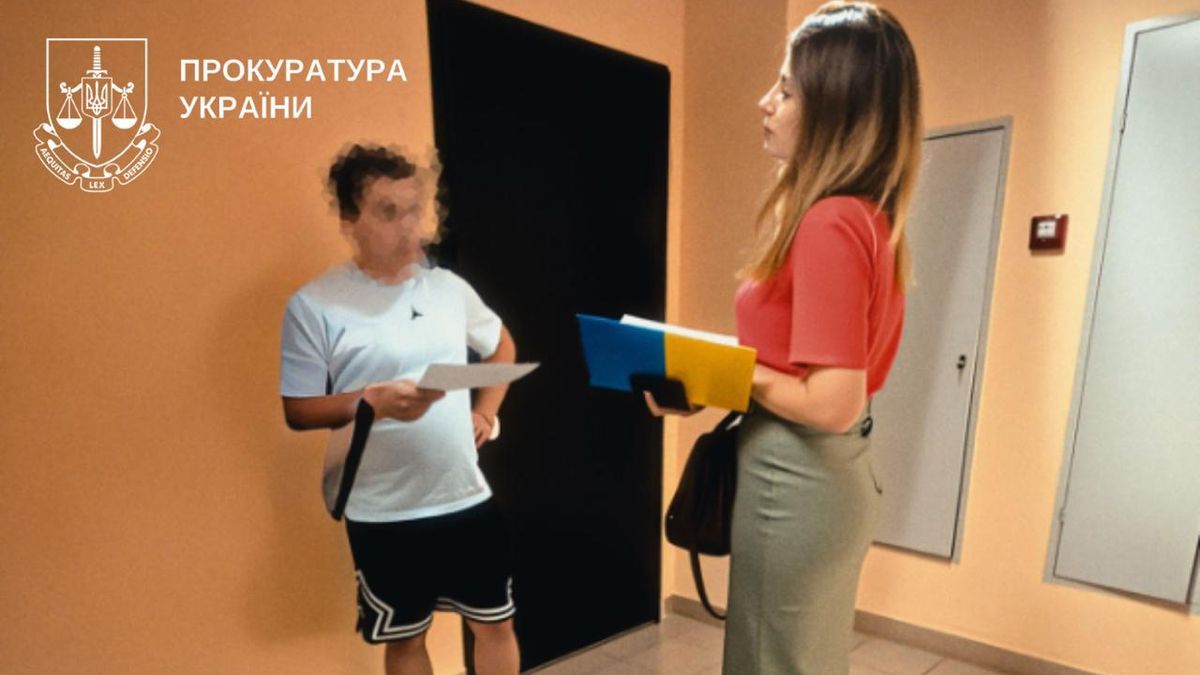 Автомийка на чужій землі: у Києві викрили незаконну забудову Представниця прокуратури вручає чоловіку повідомлення про підозру в коридорі будівлі