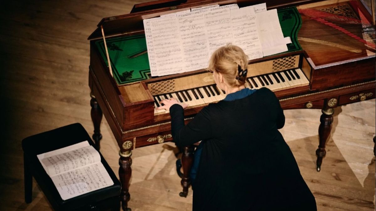 У столиці проведуть Kyiv Baroque Fest-2025: 42 події за 12 днів Жінка грає на старовинному клавесині, ноти лежать на пюпітрі та стільчику