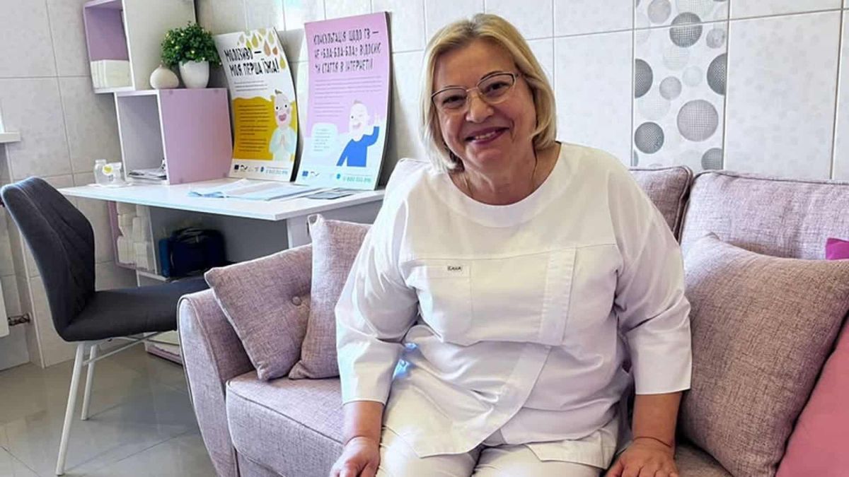Акушерка з Києва прийняла близько 10 тисяч пологів за 44 роки Акушерка у білому медичному халаті сидить на дивані в кабінеті жіночої консультації