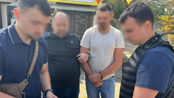 У Києві затримали начальника відділу ДПС за вимагання $500 щомісяця Правоохоронці затримують підозрюваного в організації незаконного переправлення через державний кордон, четверо чоловіків біля кіоску, обличчя розмиті