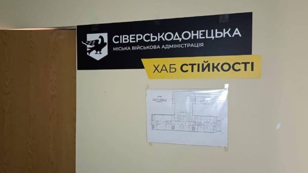 Нова система евакуації: як допомагатимуть людям із прифронту На стіні приміщення розміщено вивіску «Сіверськодонецька міська військова адміністрація. Хаб стійкості»