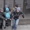 Головні новини Києва | Kyiv.News Люди допомагають людині на інвалідному візку подолати сходи біля входу до будівлі — проблема безбар'єрного простору в Україні