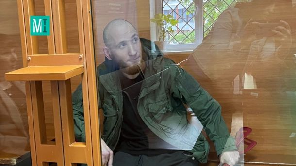 Суд скасував зупинку справи про Садибу Дмитрієва — забудовника можуть позбавити інших будівель Білявий чоловік за ґратами у слідчій кімнаті, на задньому фоні вікно з зеленню.