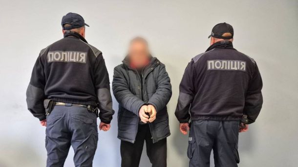 Як візит першої леді Австрії до Ірпеня підсилює відновлення Київщини Двоє поліцейських у темній формі стоять по обидва боки чоловіка в наручниках, який одягнений у куртку, із розмитим обличчям