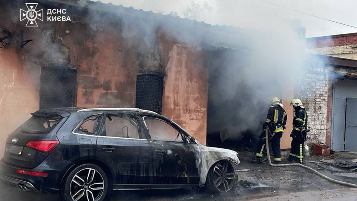 Пожежа в Оболонському районі: згоріли склад та елітне авто Пожежники біля складу, з якого йде дим та знищений вогнем автомобіль