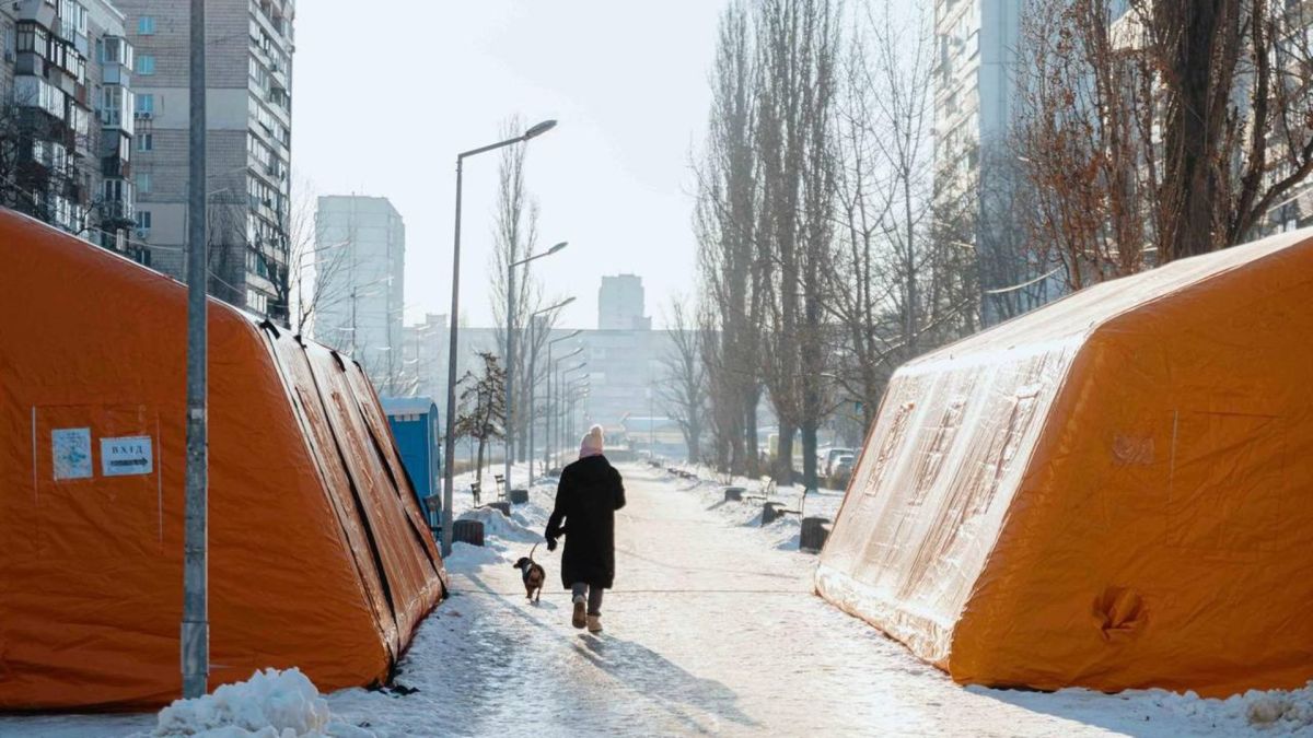 У Києві розгорнуто 79 нових пунктів обігріву після нічної атаки Жінка з песиком проходить повз пункти обігріву