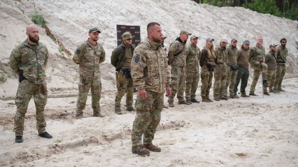 На Київщині судитимуть групу за незаконну вирубку лісу на понад 2 мільйони Група військових у камуфляжній формі стоїть шеренгою на піщаній місцевості, один боєць виступає попереду