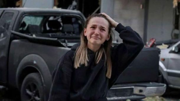 У Києві підірвали ворожий боєприпас: вибух пролунав у Шевченківському районі Жінка у жалобній позі, з сумом на обличчі, стоїть на фоні зруйнованих автомобілів біля будівлі, що відображає трагічні наслідки конфлікту в Києві.