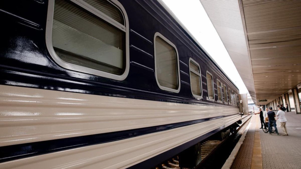 Київ-Бухарест: на новий потяг продали 2100 квитків за 2 тижні Синьо-білий потяг Укрзалізниці стоїть на пероні, біля нього кілька пасажирів, один з них на кріслі колісному