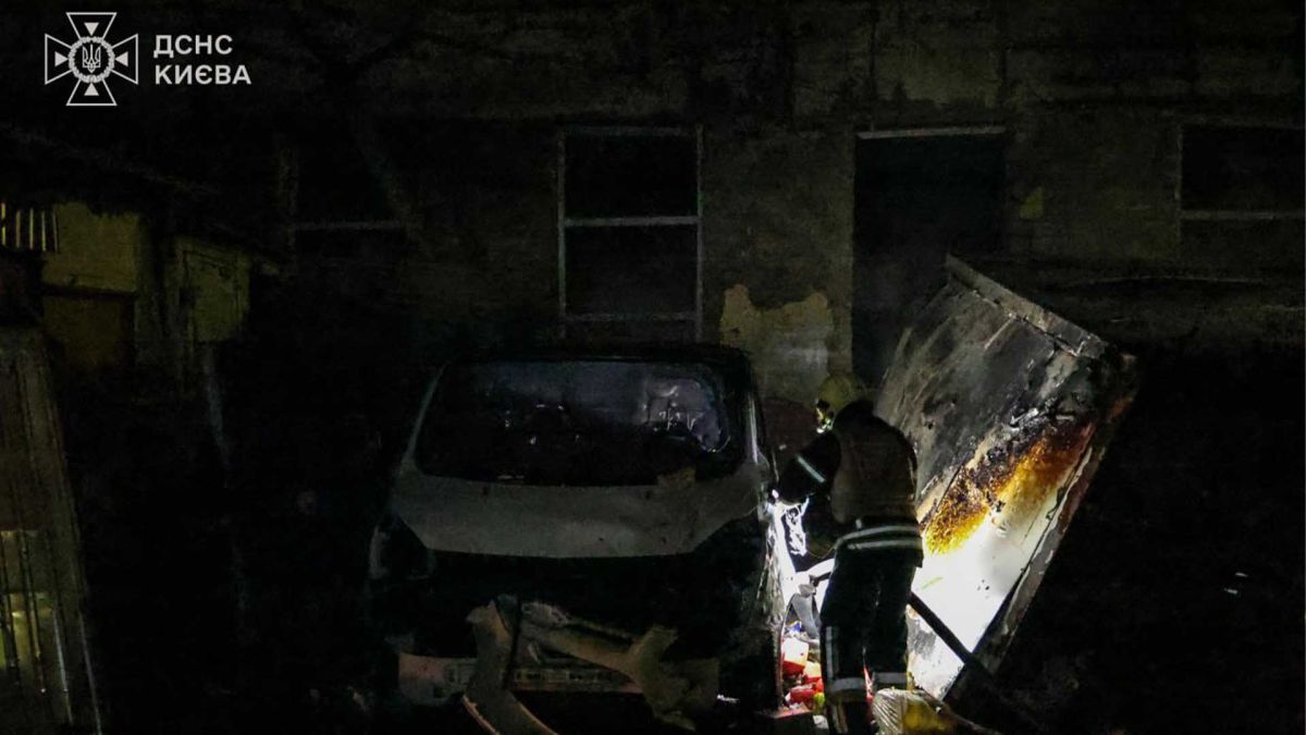 Печерський район під ударом: 4 вантажівки згоріли після нічної атаки дронів Співробітник ДСНС біля пошкодженого автомобіля