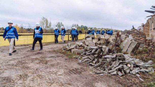 Ярмарок вакансій у метро: 22–23 жовтня на Майдані Чоловіки та жінки в синіх жилетах і касках ходять з-поміж зруйнованих будинків у приватному секторі