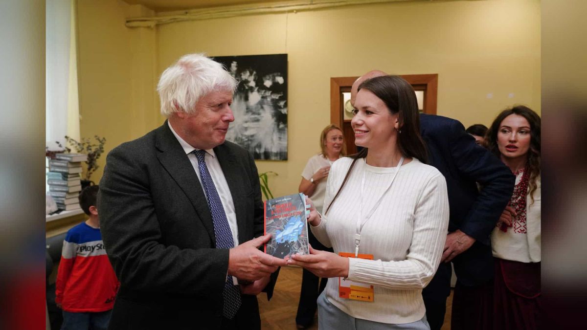 Боріс Джонсон отримав у подарунок книгу «Вижити в Гостомелі» Боріс Джонсон тисне руку Ксенії Дворніковій і тримає книгу «Вижити в Гостомелі» на Львівському BookForum