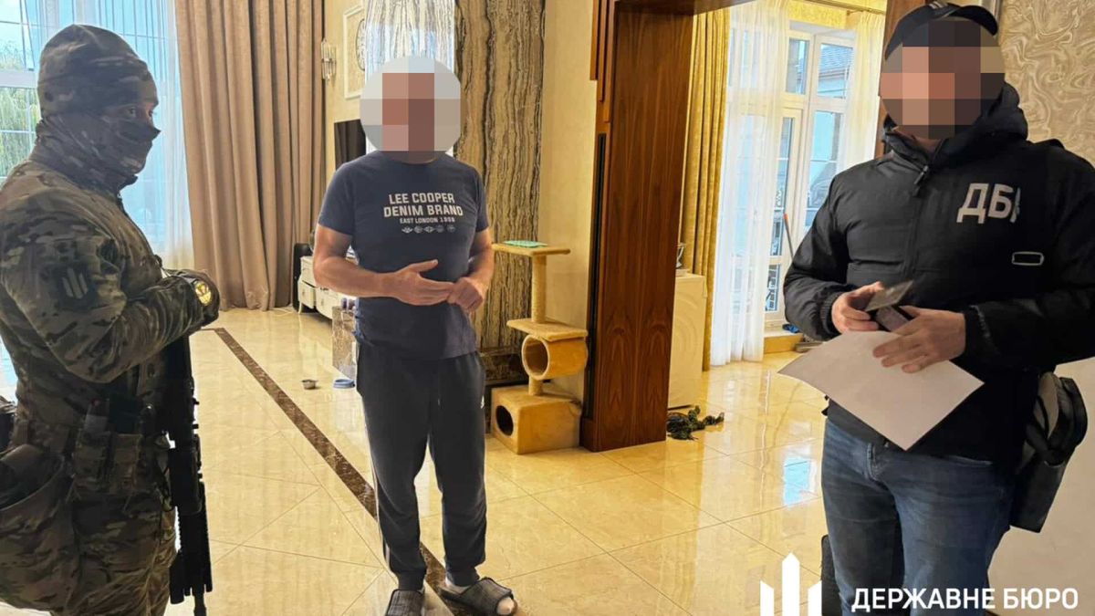Нардепа підозрюють у зраді та шахрайстві: 14,5 млн на авто Чинний народний депутат стоїть в своїй квартирі і біля нього двоє правоохоронців, усі із заблюреними обличчями