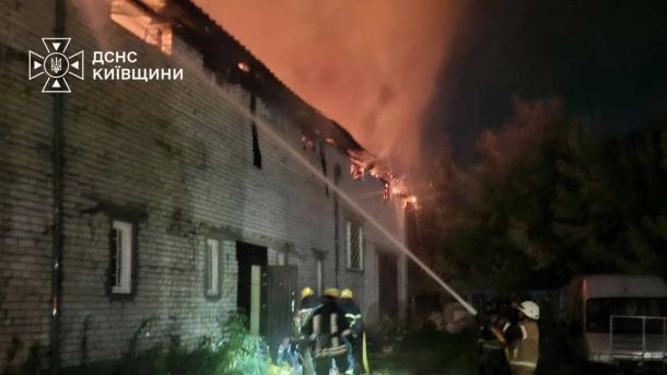 Ворог атакував Київщину: пошкоджено будинки й виробничі приміщення Рятувальники ДСНС Київщини подають воду на палаючий дах цегляної будівлі поблизу автомобіля