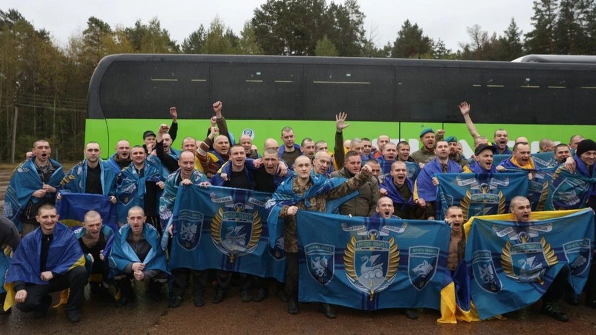 Україна визволила з полону РФ 205 людей: 185 оборонців та 20 цивільних (фото) Українські військовополонених після повернення з російського полону — чоловіки з усмішками, обгорнуті державними прапорами