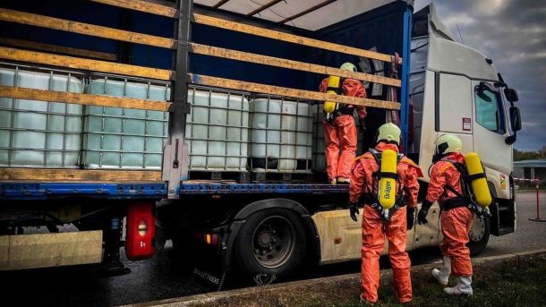 Обшуки в КМДА — це антикорупційна чистка чи політична розправа? Троє людей у захисних костюмах оглядають вантажівку з великими пластиковими ємностями