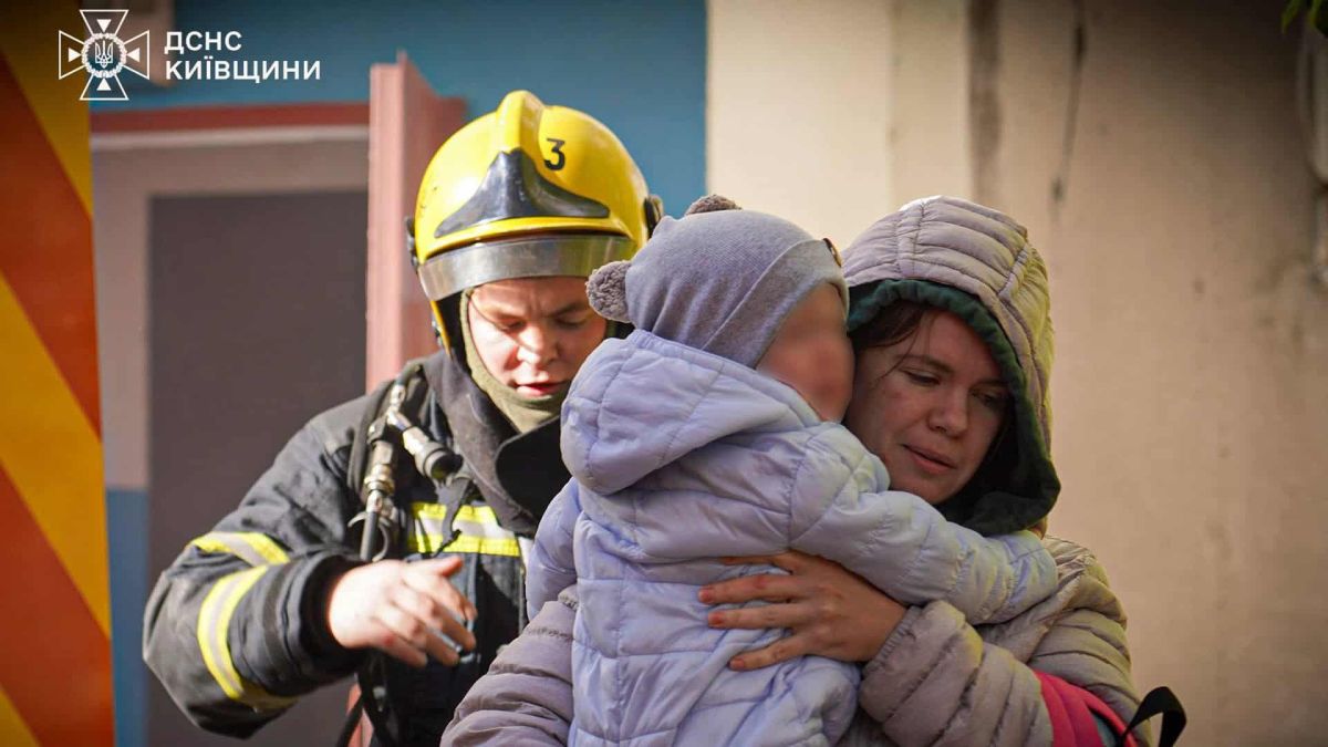 У Білій Церкві з пожежі врятували дворічну дитину Рятувальник виводить з підʼїзду жінку з дитиною на руках