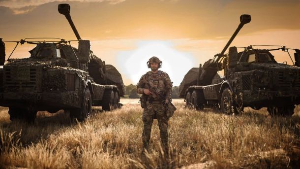 Росія втратила 1200 військових за добу: останні новини з фронту Військовий ЗСУ стоїть між двома вантажівками з гарматами