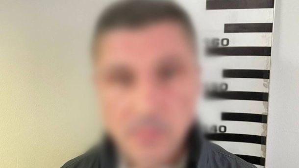 У Печерському районі Києва чоловік випав з вікна багатоповерхівки Поліцейське фото затриманого підозрюваного з розмитим обличчям на тлі ростоміра, чоловік у темному одязі