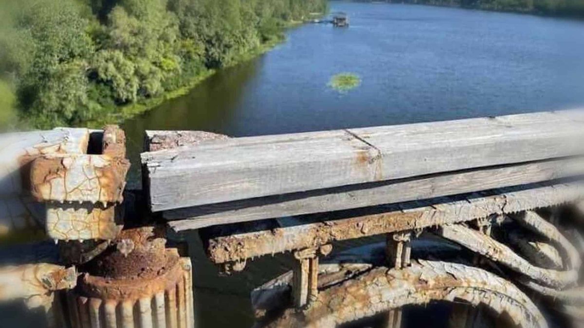 Активіст просить Кличка залучити Вільнюс для ремонту аварійного мосту Патона Аварійний стан мосту імені Патона в Києві: іржаві металеві конструкції і зношені дерев'яні елементи на тлі Дніпра — фото до петиції про ремонт