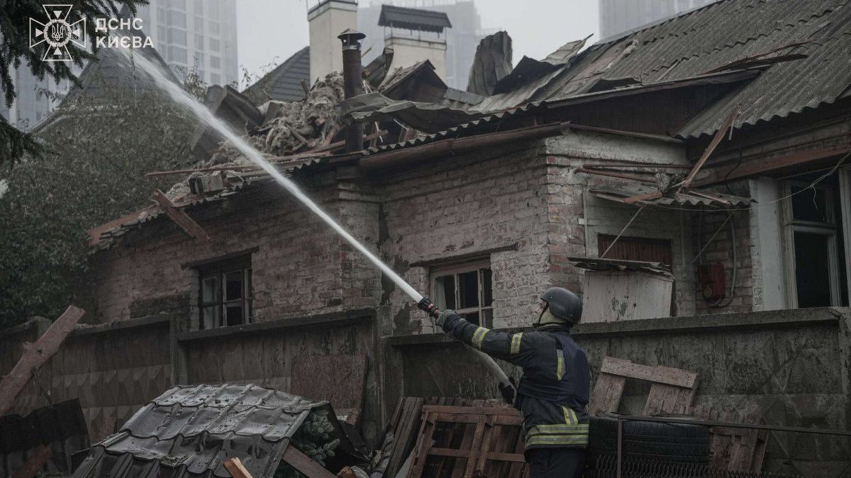У Києві внаслідок атаки загинуло подружжя Пожежник гасить вогонь у дворі куди влучила російська ракета, він тримає брандспойт з якого йде вода