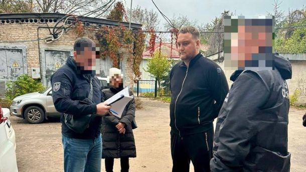 У Чабанах посадовця підозрюють у розтраті 2,8 млн під час будівництва школи Правоохоронець зачитує текст перед чоловіком великої статури