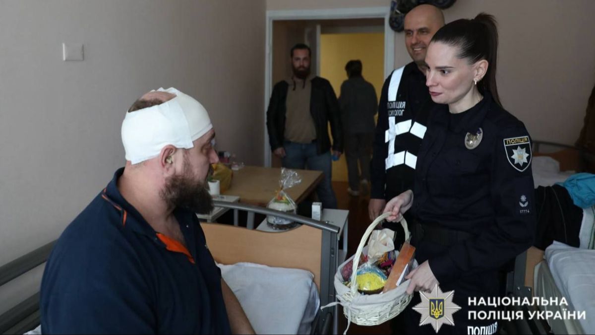 Поліцейські Київщини відвідали поранених побратимів у лікарнях МВС напередодні Великдня Поліцейська-психологиня передає великодній кошик пораненому військовому з перебинтованою головою у палаті відомчої лікарні МВС
