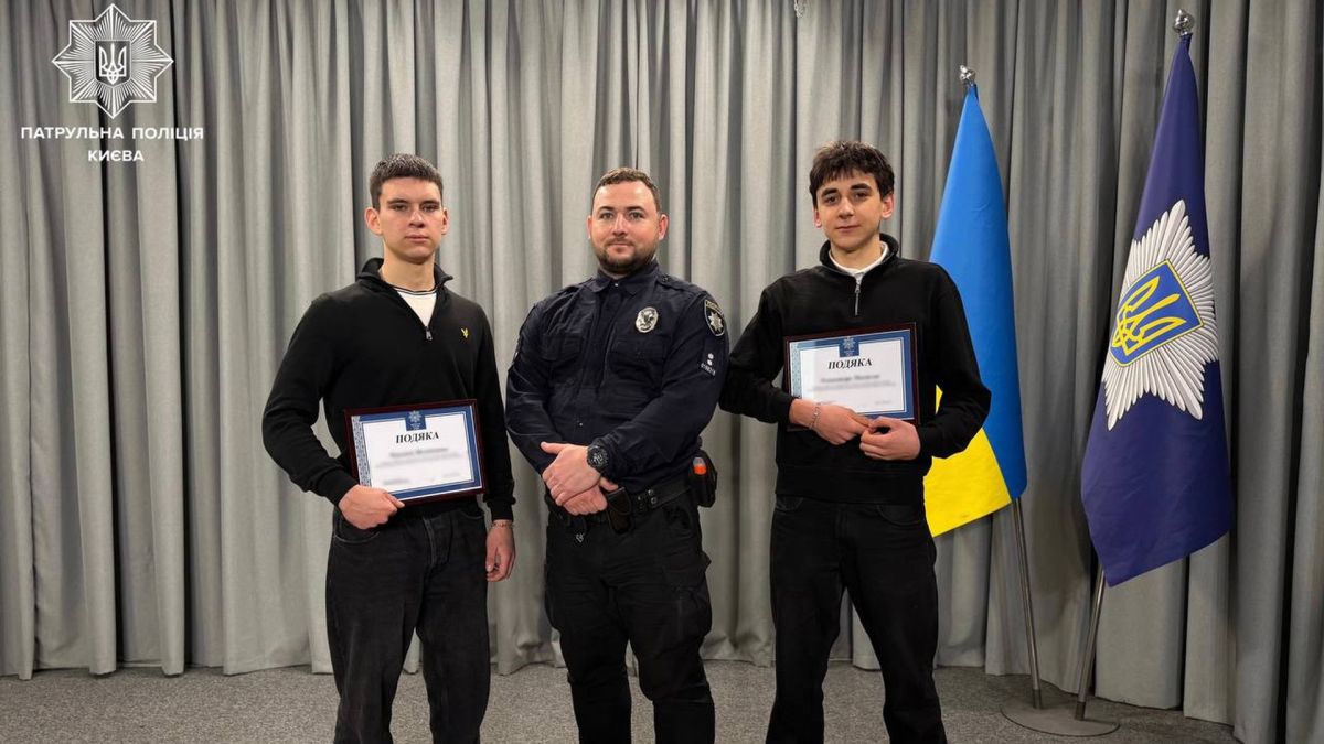 Школярі у Києві здали вербувальника РФ: деталі історії Поліцейський стоїть в оточенні двох школярів, яким вручили грамоти