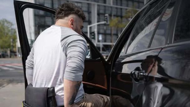 До 50 тисяч за переобладнання авто: кому і як отримати Чоловік з інвалідність з колісного крісла пересідає в автомобіль на місце водія