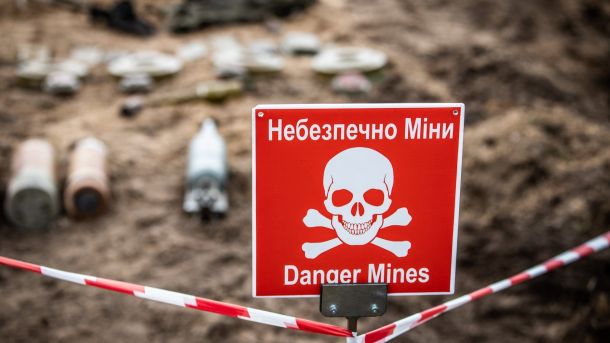 Жінку врятували з балкону 11 поверху в центрі Києва Червоний попереджувальний знак із зображенням черепа та кісток і написом «Небезпечно, міни!»